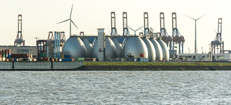 Gas storage reservoir, wind turbines and cranes in the harbour area in Hamburg, Germany