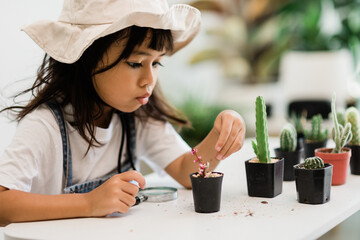 Asian little girl is planting plants in the house, concept of plant growing learning activity for a...