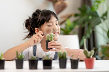 Asian little girl is planting plants in the house, concept of plant growing learning activity for a preschool kid and child education for the tree in nature
