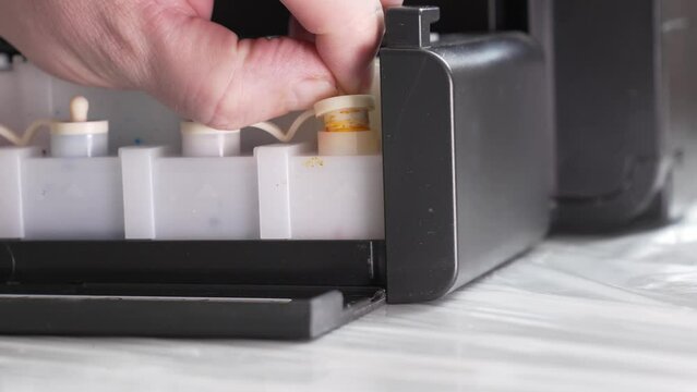 filling the printer with yellow ink. continuous ink supply system