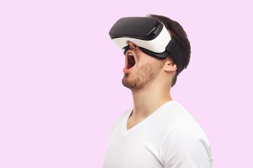 Studio portrait of screaming young man in VR virtual reality glasses