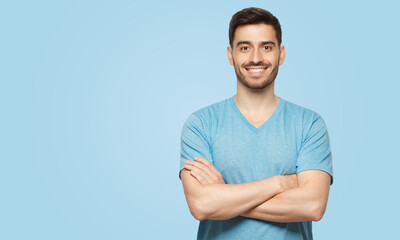 Banner of young handsome man wearing blue t-shirt, standing with crossed arms