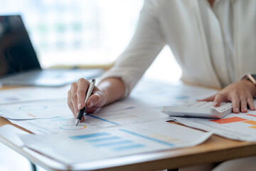 Business woman pointing to a graph of financial data to plan investments in business market.