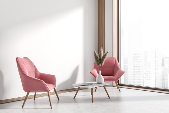 Corner view on bright office interior with two pink armchairs