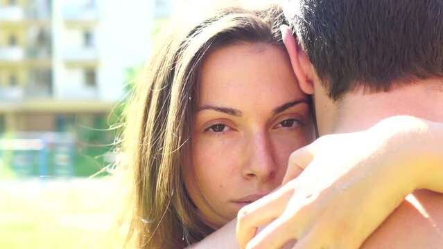 Young loving couple outdoors hugging and looking away, relationships concept. Lovers girlfriends close up sensual face. Close-up portrait of a caucasian young loving couple embracing.