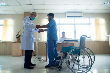 , Doctor give advice and examination about knee for patient sitting on wheelchair at hospital or medical clinic