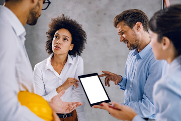 A businessman showing tablet to colleagues architects.