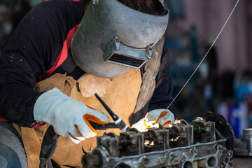 Industrial welder worker metal welding steel works using argon arc welding machine to weld steel at...