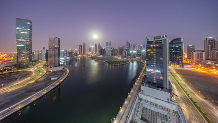 Cityscape of skyscrapers in Dubai Business Bay with water canal aerial night to day timelapse