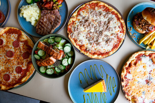  Traditional Turkish cuisine. Pizza, pita, pidesi, sucuk, hummus, kebab. Many dishes on the table. Serving dishes in restaurant. Background image. Top view, flat lay