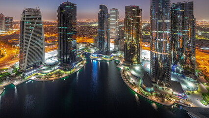 Tall residential buildings at JLT aerial night to day timelapse, part of the Dubai multi commodities centre mixed-use district.