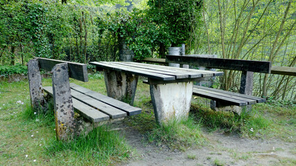 Old weathered park benches made of wood & stone