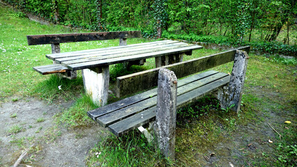 Old weathered park benches made of wood & stone