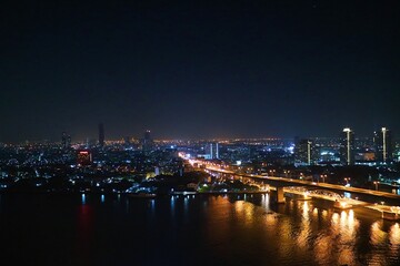 Fototapeta na wymiar Urban night view next to the river and bridge piers
