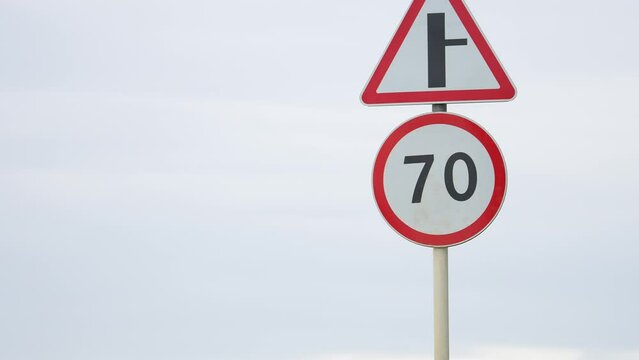Speed limit on the road. 70 km per hour. Crossroads. Slow down. A sign shows a speed limit of 70. Vehicles safety movement control on the road. blurred in the background