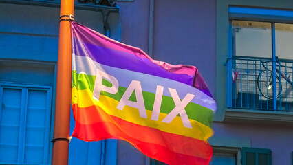 The rainbow flag of peace in the night with PAIX text meaning PEACE in French.