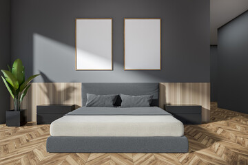 Front view on dark bedroom interior with two white posters