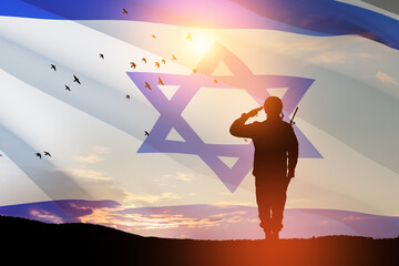 Fototapeta premium Silhouette of soldier saluting against the sunrise in the desert and Israel flag. Concept - armed forces of Israel.