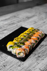 Sushi Set nigiri and sushi rolls on black stone slate plate board top view