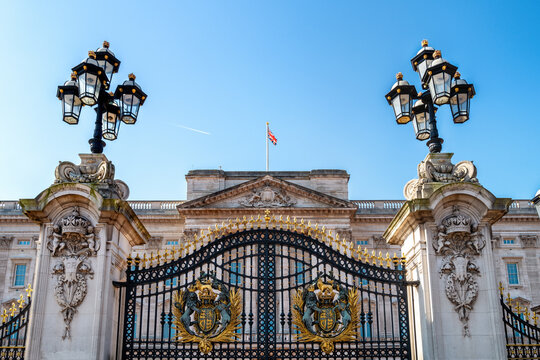 Buckingham Palace, London, with coat of arms and ornate lanterns. Residence to Queen Elizabeth II, who has reigned for 70 years.