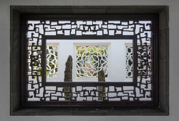 Rectangular window and ornate wooden frame in a classical Chinese garden
