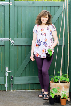 Lady posing with runner bean plants.