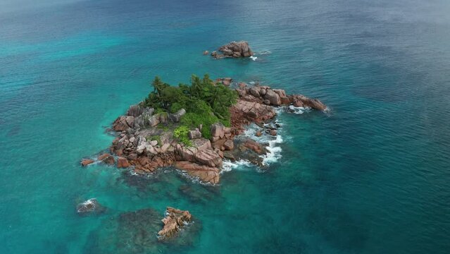 Aerial arc shot around small oasis desert island St. Pierre, Praslin