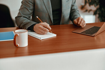 Close up of man using pencil while making notes in the office