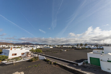 Arial view of Yaiza a white town with black soil with the volcanoes on Timanfaya Park on the background in Lanzarote, Canary Islands in Spain