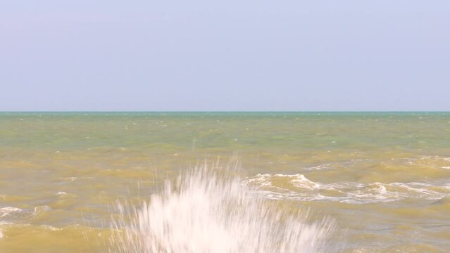 The simplicity of the sky contrasts with the dark horizon.  when you can see the sea color in separate layers when approaching the shore and the color is not bright  with waves so strong that they spl