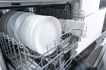 Open dishwasher with clean dishes after washing