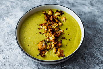 vegan homemade creamy broccoli soup with roasted cauliflower topping, healthy plant-based food