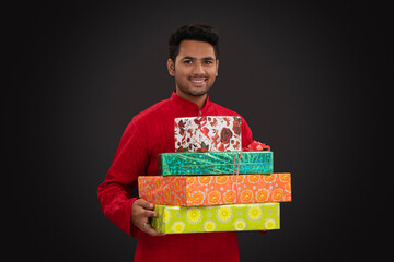 Happy Indian man holding gift boxes
