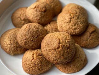 Homemade cookies on a white plate. Butter round cookies close-up. Cookies on a blurred background, top view.