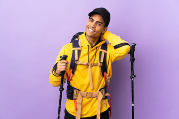 African American man with backpack and trekking poles over isolated background laughing