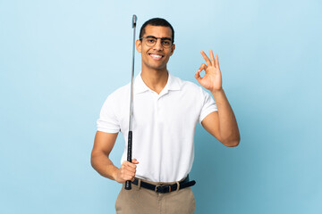 African American man over isolated blue background playing golf making OK sign