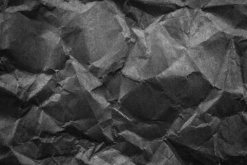 Background from crumpled black paper. Dark paper with folds, scuffs and waves