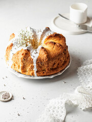 Bundt cake decorated with icing sprinkles and flowers. Easter orthodox sweet bread in a high key