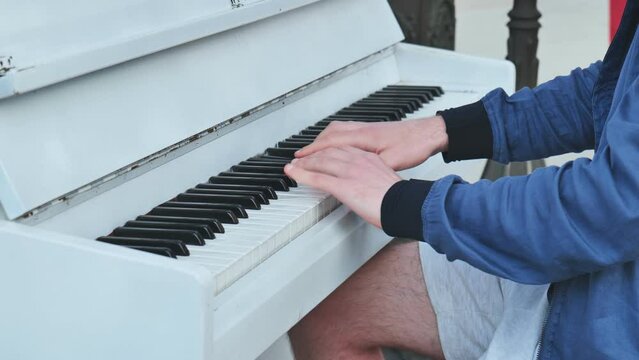 A street pianist plays the piano in the city.