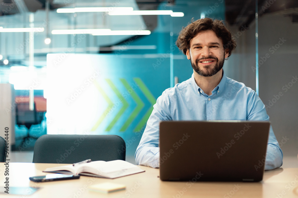 Poster portrait of smiling man using laptop and posing