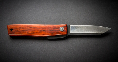 Traditional wooden japanese pocket knife on black background