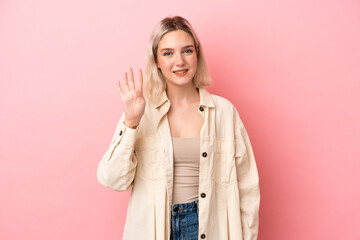 Young caucasian woman isolated on pink background happy and counting four with fingers