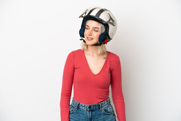 Young caucasian woman with a motorcycle helmet isolated on white background looking to the side and smiling