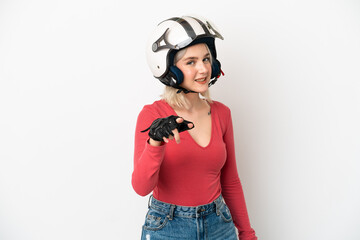 Young caucasian woman with a motorcycle helmet isolated on white background pointing front with happy expression