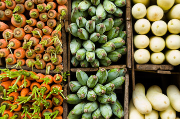 Several varieties of tropical vegetables neatly arranged for sale - obrazy, fototapety, plakaty