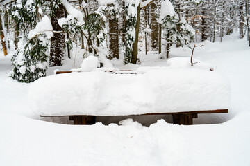 Ein Abdruck vom Sitzen befindet sich im Schnee auf einer Bank; Bank zum Sitzen bedeckt mit hohem Schnee