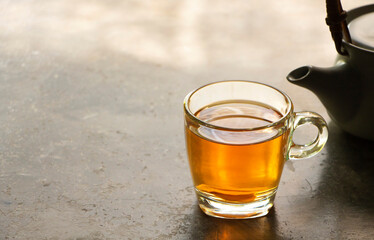 Photo of cup of hot ginger tea on a rustic concrete table.