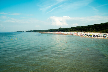 wakacje ludzie odpoczywają latem na plaży w Kołobrzegu - obrazy, fototapety, plakaty
