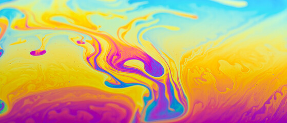 Psychedelic abstraction formed by light interferences on the surface of a soap bubble bright background.