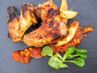 Grilled Hot Chicken Wings with Potato Wedges, a Spicy Dip and Field Salad